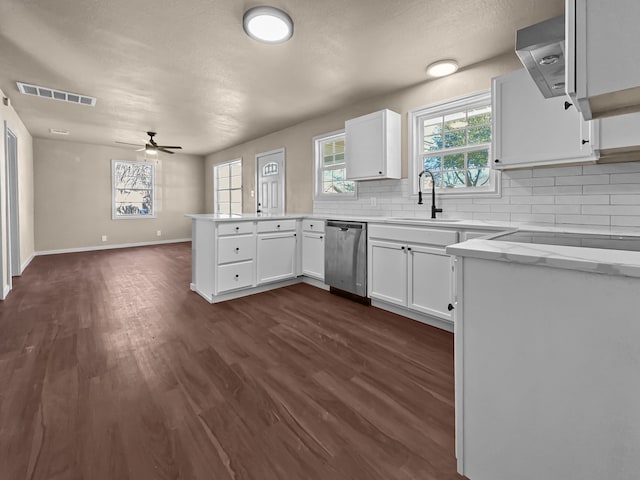 kitchen with sink, stainless steel dishwasher, kitchen peninsula, and white cabinets