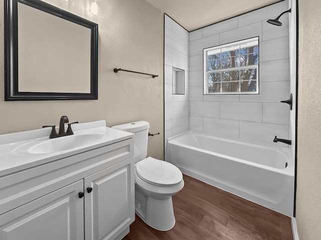 full bathroom featuring vanity, hardwood / wood-style floors, toilet, and tiled shower / bath