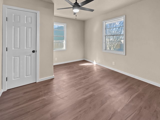 unfurnished room with ceiling fan, plenty of natural light, and dark hardwood / wood-style flooring