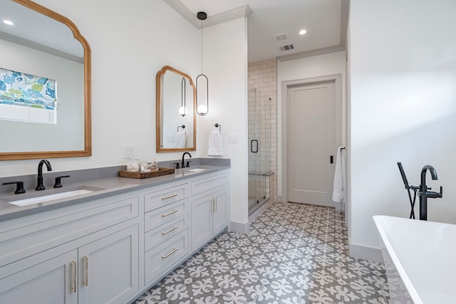 bathroom featuring a stall shower, double vanity, a sink, and tile patterned floors