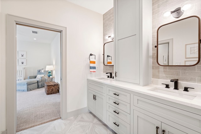 bathroom featuring tasteful backsplash, parquet flooring, and vanity