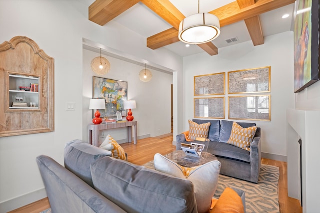 living room featuring hardwood / wood-style flooring, a fireplace, and beamed ceiling