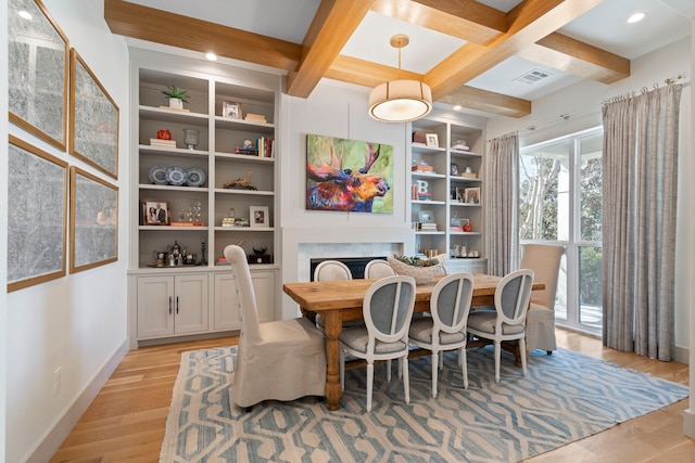 dining area featuring coffered ceiling, a fireplace, visible vents, baseboards, and light wood finished floors