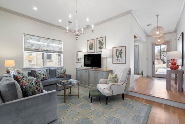 living area featuring visible vents, ornamental molding, wood finished floors, a notable chandelier, and recessed lighting