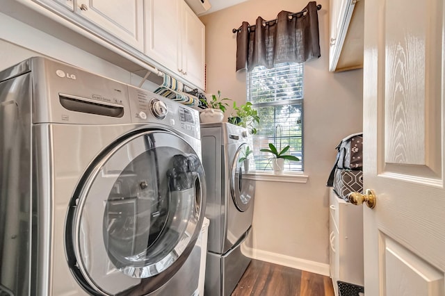 washroom with cabinets, dark hardwood / wood-style flooring, and washer and clothes dryer