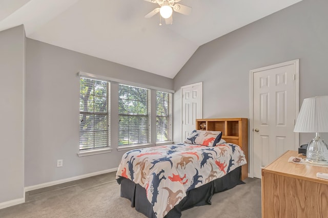 carpeted bedroom featuring two closets, vaulted ceiling, and ceiling fan