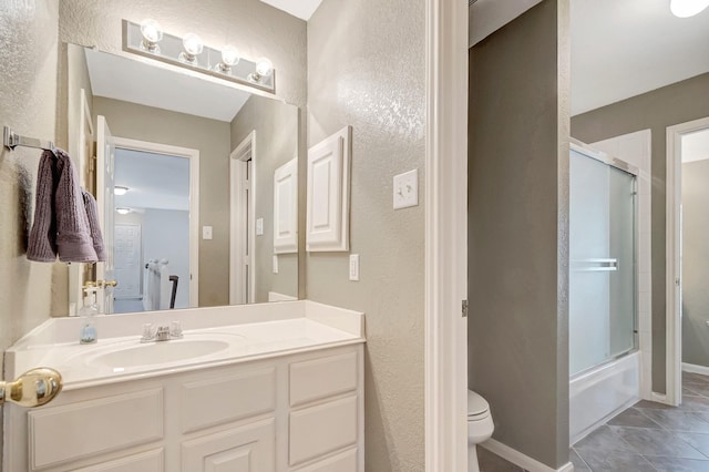 full bathroom with enclosed tub / shower combo, vanity, tile patterned floors, and toilet