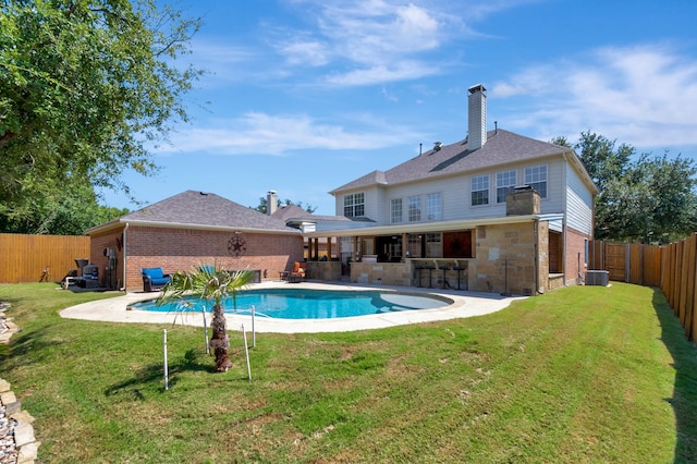 view of pool with central AC, an outdoor bar, and a lawn