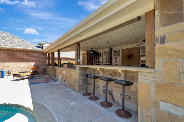 view of patio / terrace featuring ceiling fan and a bar