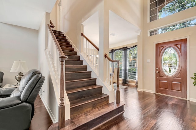 foyer entrance with dark wood-type flooring and a high ceiling