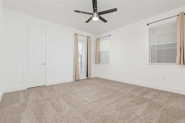 spare room with ceiling fan, carpet floors, and baseboards