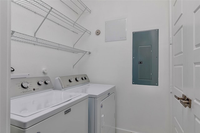 clothes washing area featuring laundry area, electric panel, and washing machine and clothes dryer