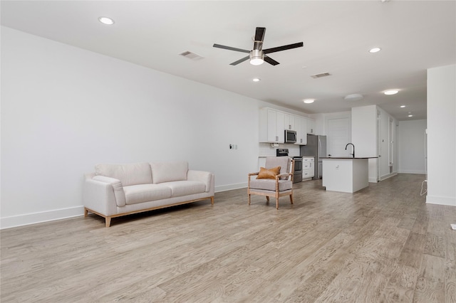 living area featuring recessed lighting, visible vents, light wood-style flooring, ceiling fan, and baseboards