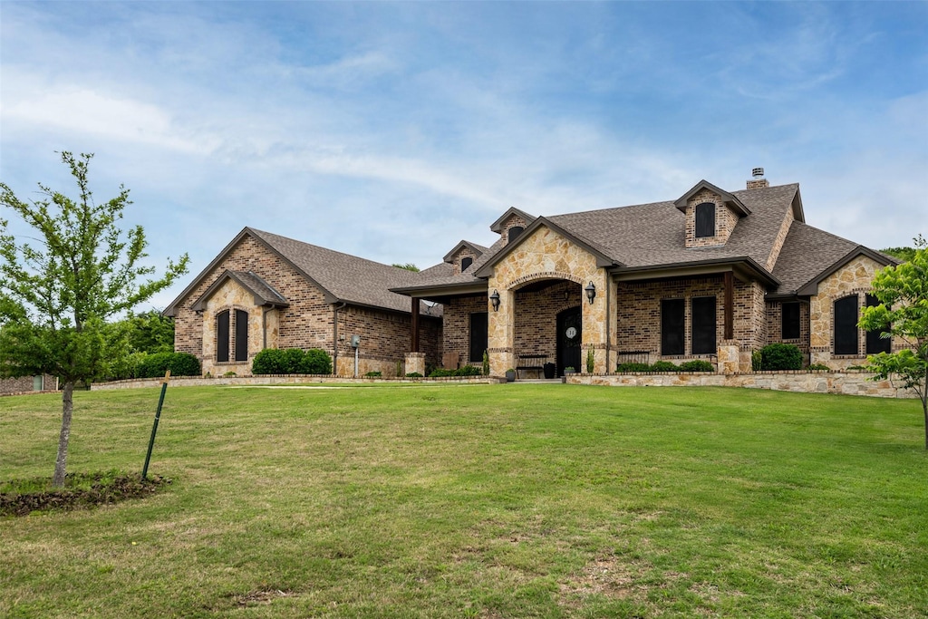 french country inspired facade with a front yard