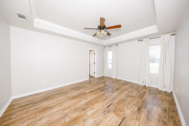 spare room featuring crown molding, light hardwood / wood-style flooring, a raised ceiling, and ceiling fan