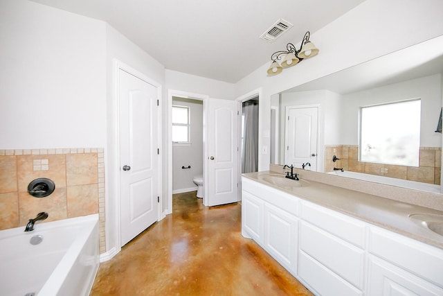 bathroom featuring vanity, a bath, concrete floors, and toilet