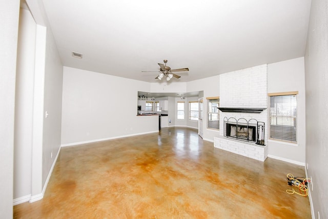 unfurnished living room with concrete flooring, a brick fireplace, and ceiling fan