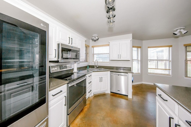 kitchen featuring stainless steel appliances, sink, and white cabinets