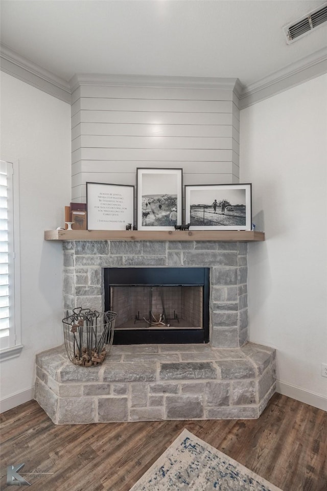 room details with a stone fireplace, wood-type flooring, and ornamental molding