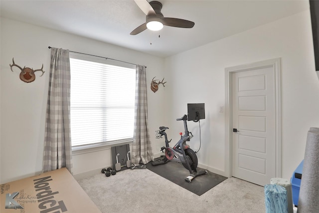 exercise room with light colored carpet and ceiling fan