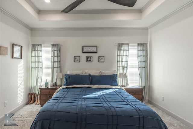 carpeted bedroom featuring ceiling fan, ornamental molding, a raised ceiling, and multiple windows