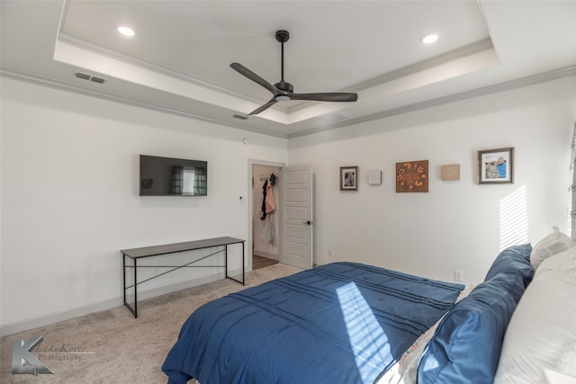 bedroom featuring crown molding, light colored carpet, a raised ceiling, and ceiling fan