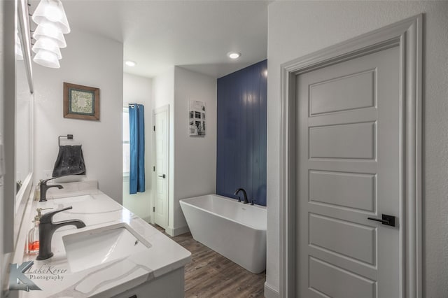 bathroom featuring a bathing tub, hardwood / wood-style floors, and vanity