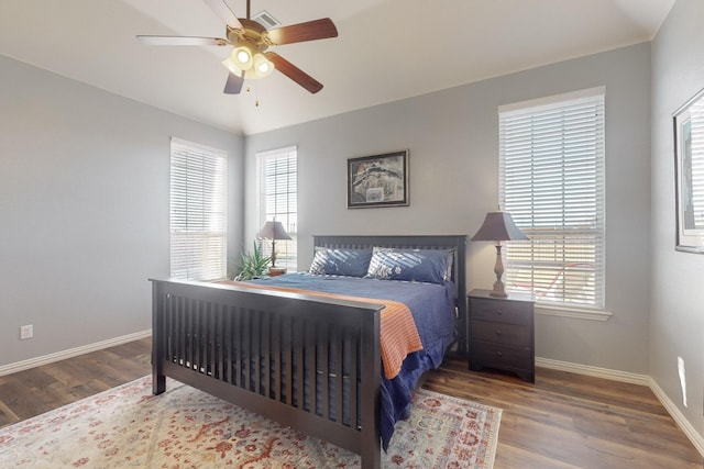 bedroom with multiple windows, hardwood / wood-style floors, and ceiling fan