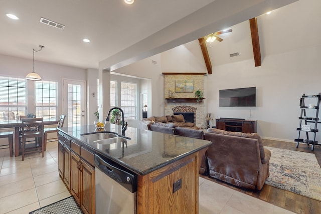 1240 Wedgewood Dr, Forney, TX 75126 - kitchen featuring stainless steel dishwasher, a sink, a stone fireplace, and visible vents
