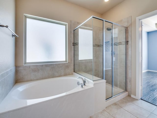 full bathroom featuring a shower stall, a bath, and tile patterned floors