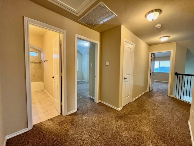 corridor featuring carpet, visible vents, and baseboards