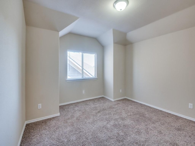 bonus room with baseboards, vaulted ceiling, and carpet flooring