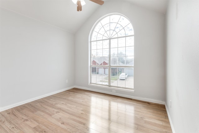 empty room with vaulted ceiling, ceiling fan, and light hardwood / wood-style flooring