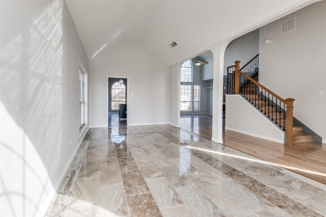 unfurnished living room with high vaulted ceiling