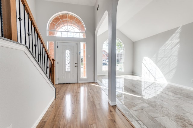 entrance foyer featuring a towering ceiling and light wood-type flooring