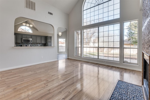 unfurnished living room featuring hardwood / wood-style flooring and high vaulted ceiling