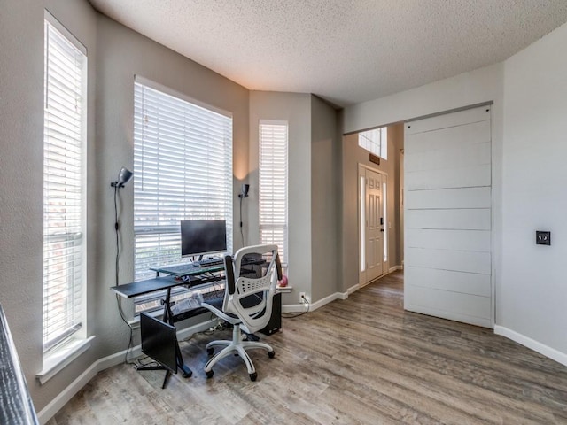 home office with hardwood / wood-style flooring, plenty of natural light, and a textured ceiling