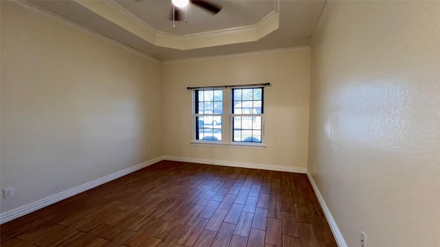 spare room with ceiling fan, ornamental molding, dark hardwood / wood-style flooring, and a raised ceiling