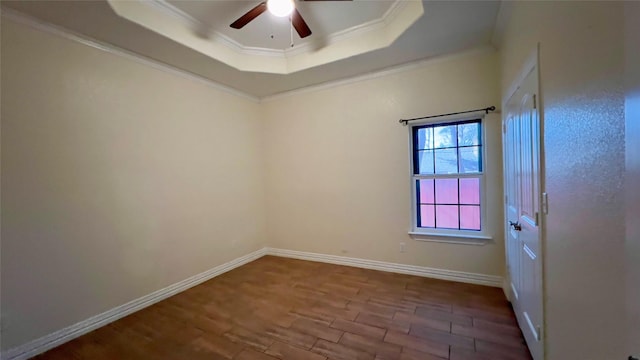 unfurnished room with a raised ceiling, ornamental molding, hardwood / wood-style flooring, and ceiling fan