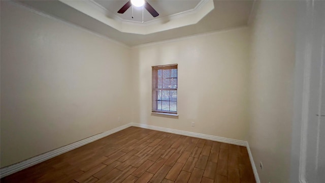 unfurnished room featuring crown molding, ceiling fan, wood-type flooring, and a raised ceiling