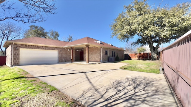 ranch-style house with a garage, central AC, and a front lawn