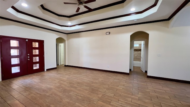 entryway with crown molding, a tray ceiling, light hardwood / wood-style flooring, and ceiling fan