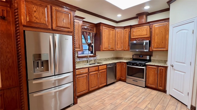 kitchen with light stone counters, sink, crown molding, and stainless steel appliances