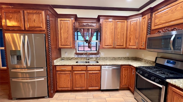 kitchen featuring stainless steel appliances, light stone countertops, and sink