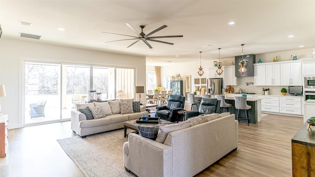 living room featuring ceiling fan and light hardwood / wood-style flooring