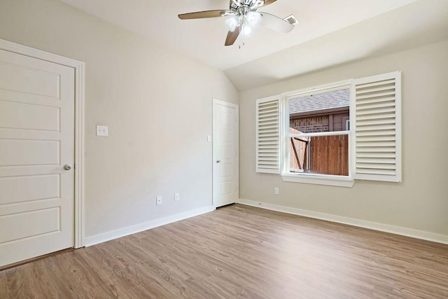 spare room featuring lofted ceiling, light hardwood / wood-style flooring, and ceiling fan