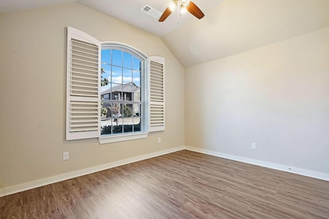 spare room featuring vaulted ceiling, wood-type flooring, and ceiling fan