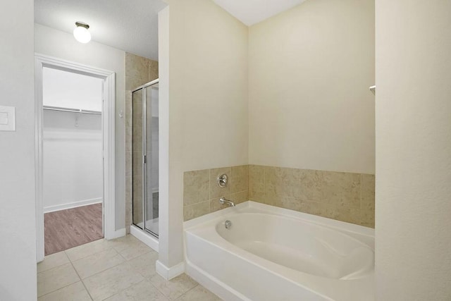 bathroom with tile patterned flooring and separate shower and tub