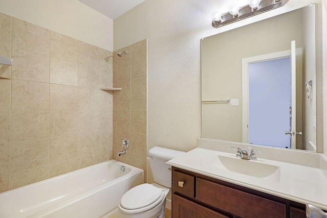 full bathroom with vanity, tiled shower / bath, and toilet