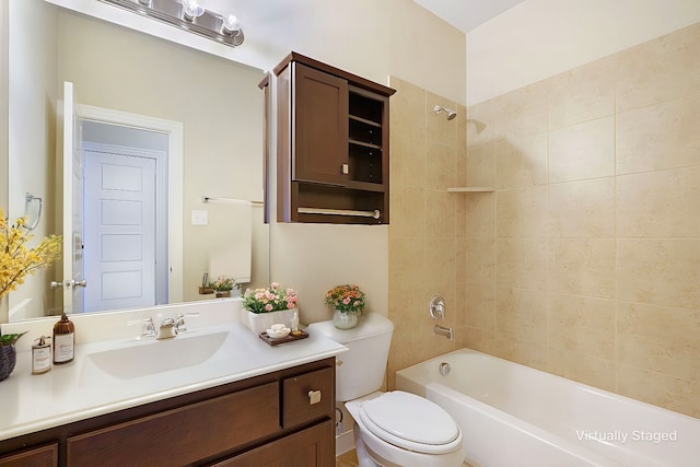 full bathroom featuring tiled shower / bath combo, vanity, and toilet